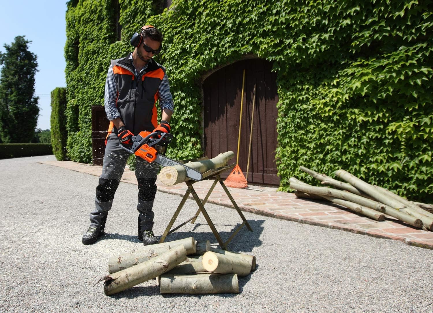 Tronçonneuse Oleo-Mac orange utilisée pour la coupe de bois