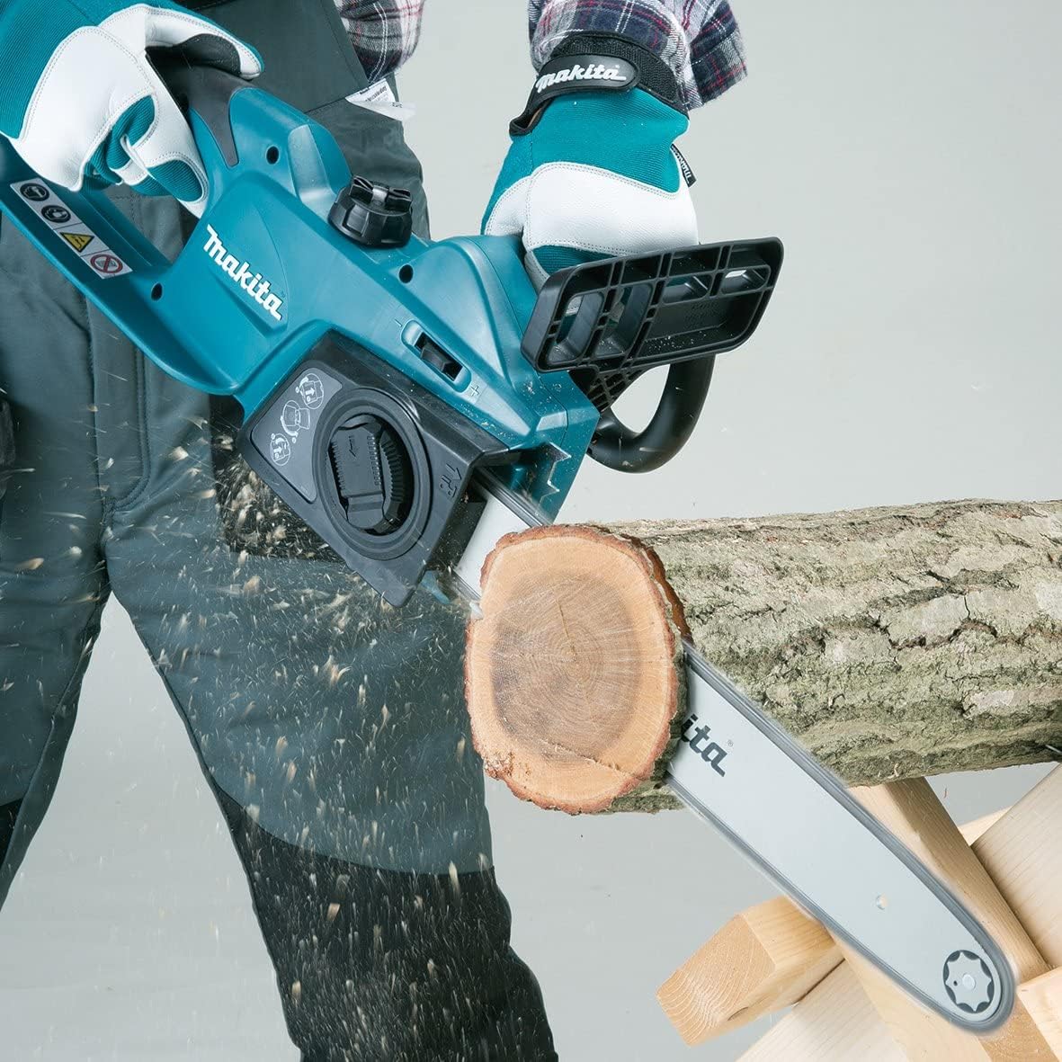 Tronçonneuse électrique Makita bleue en cours d'utilisation